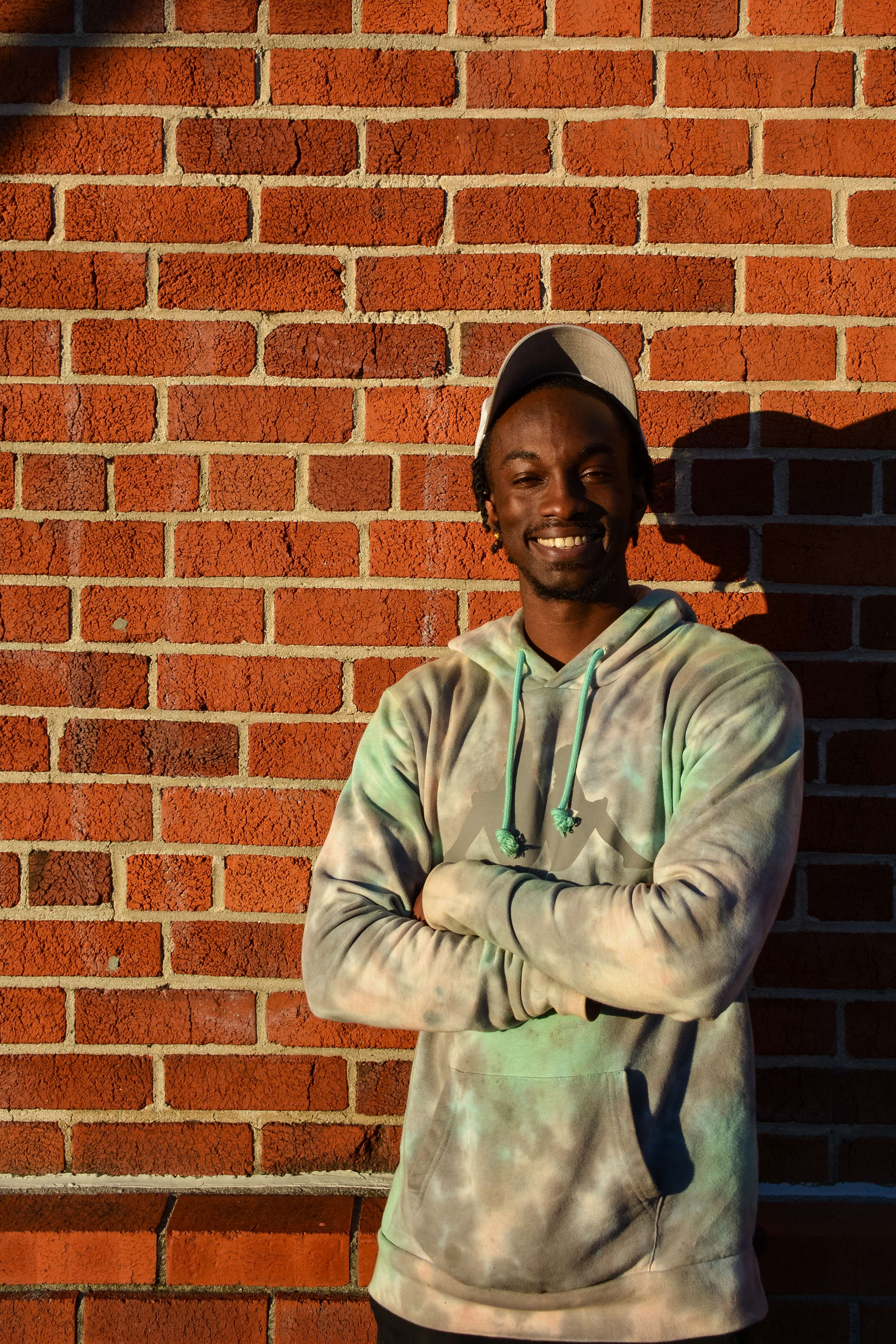 A photo of Geon, Youth Alive client, taken in front of a brick wall.